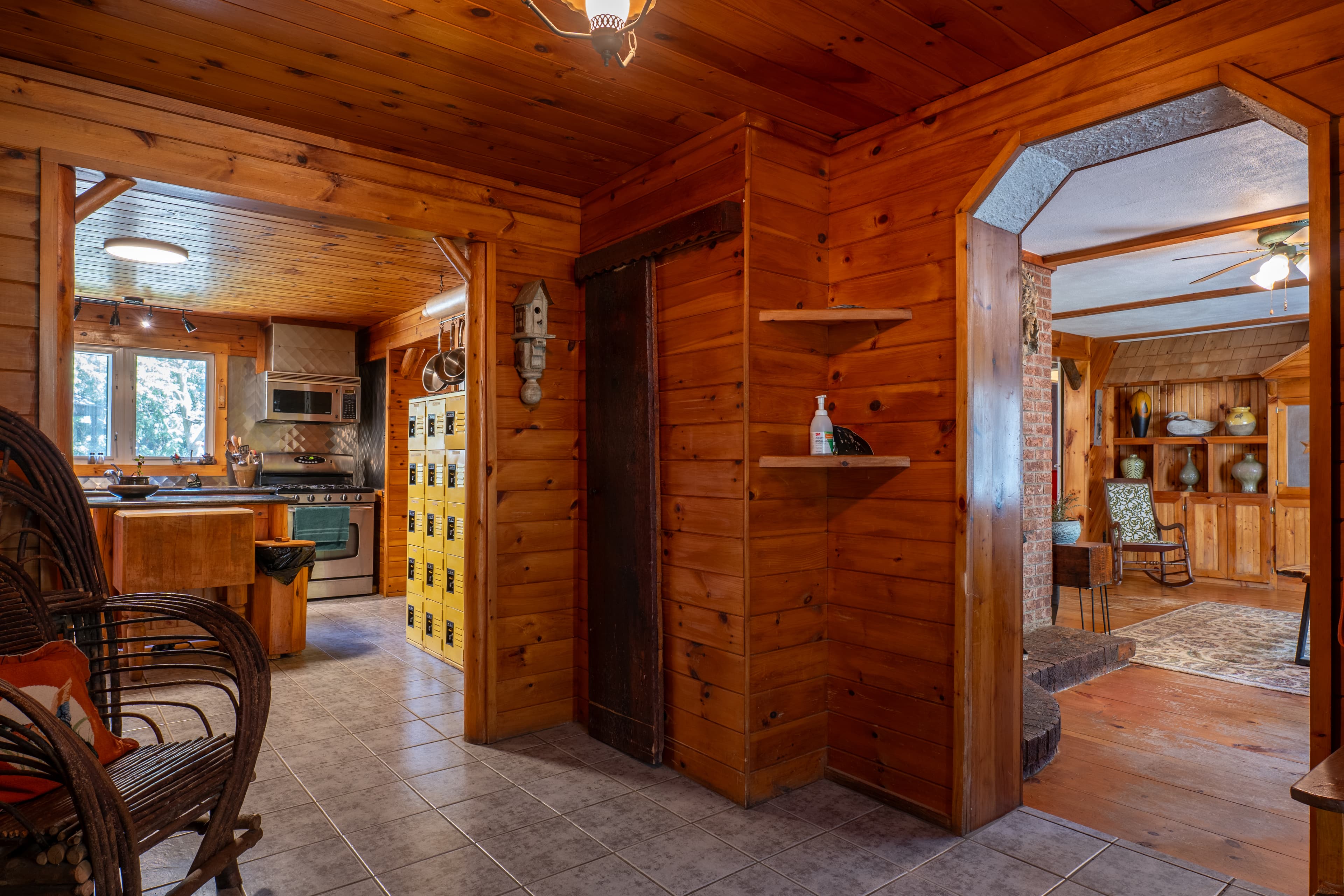 Rustic pine-paneled cabin entry looking toward the kitchen